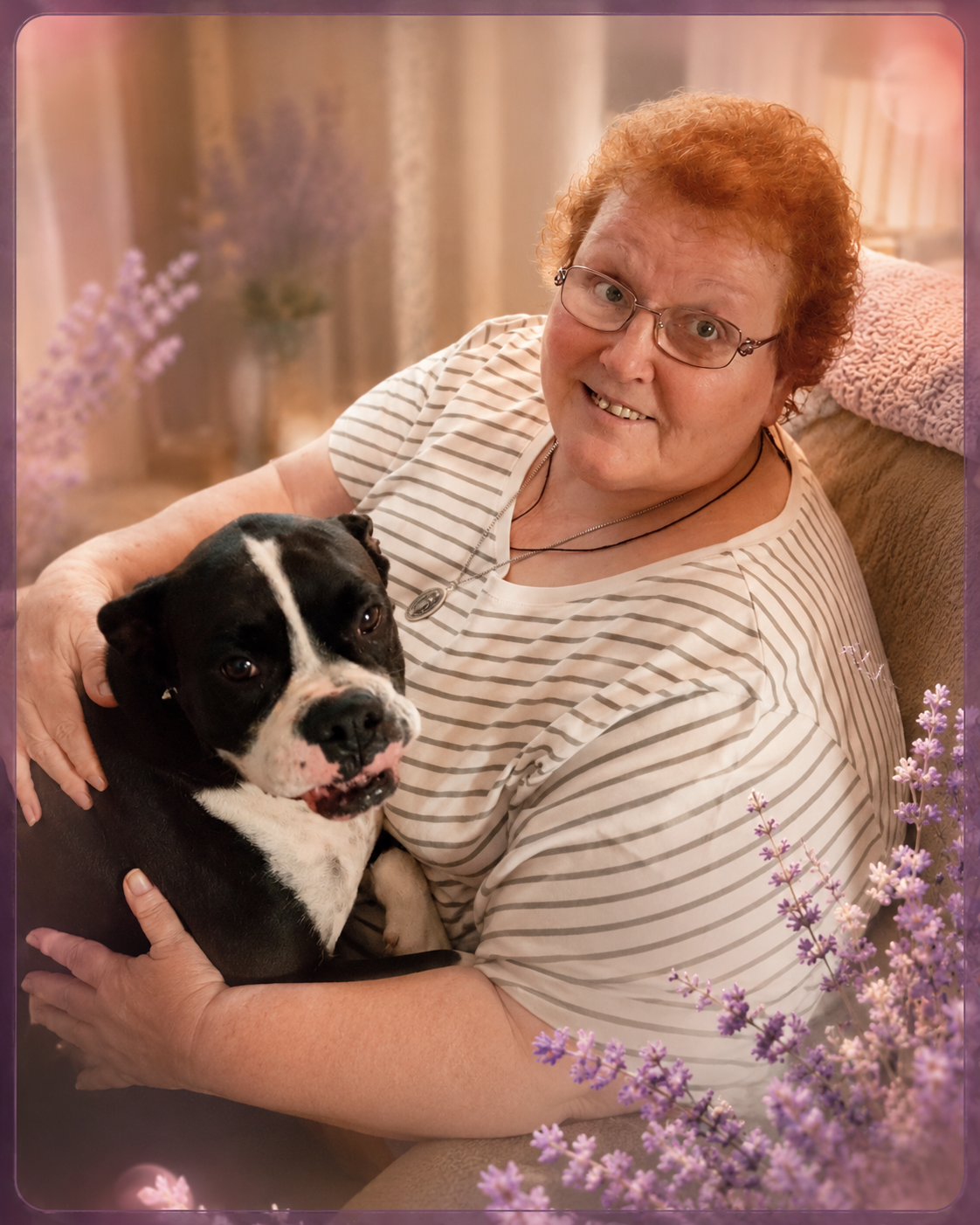 Gail smiling while holding a black-and-white dog at home