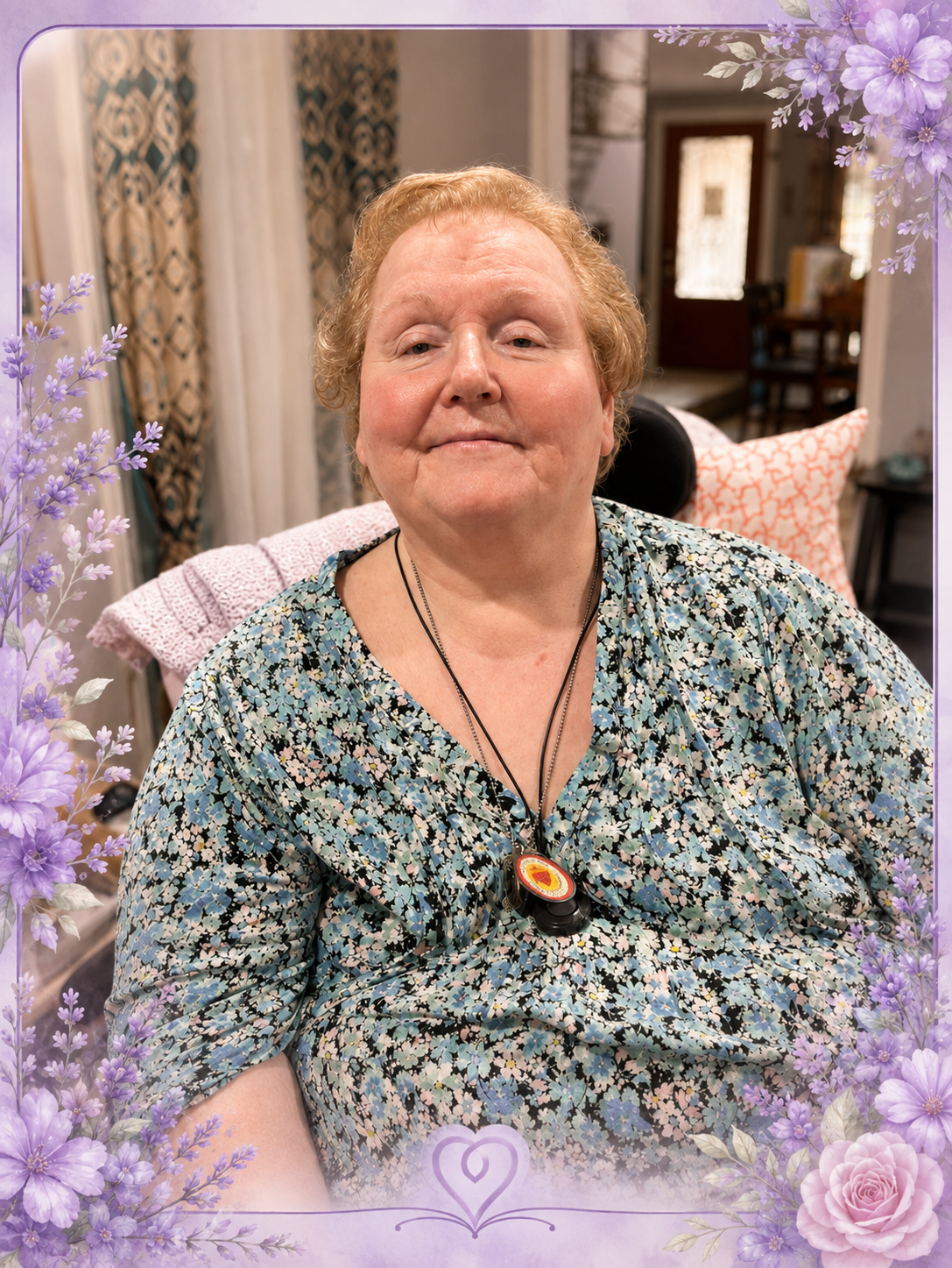 Gail seated comfortably at home in a blue floral blouse