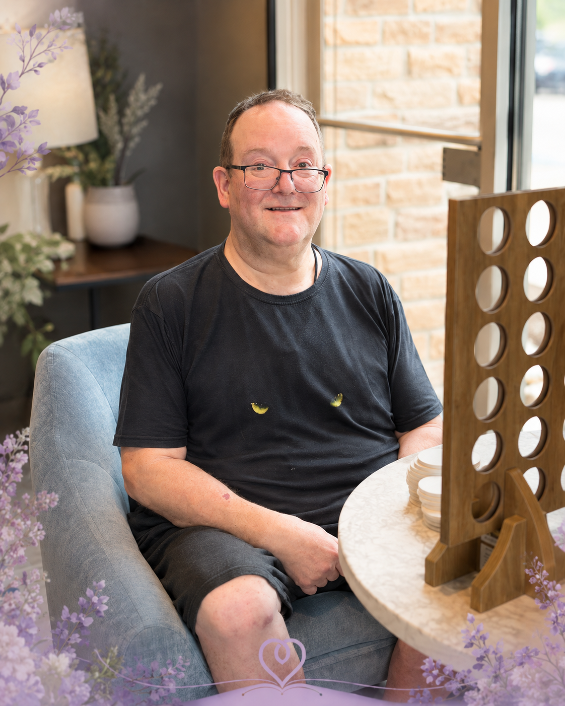 Randall seated beside a large wooden tabletop game
